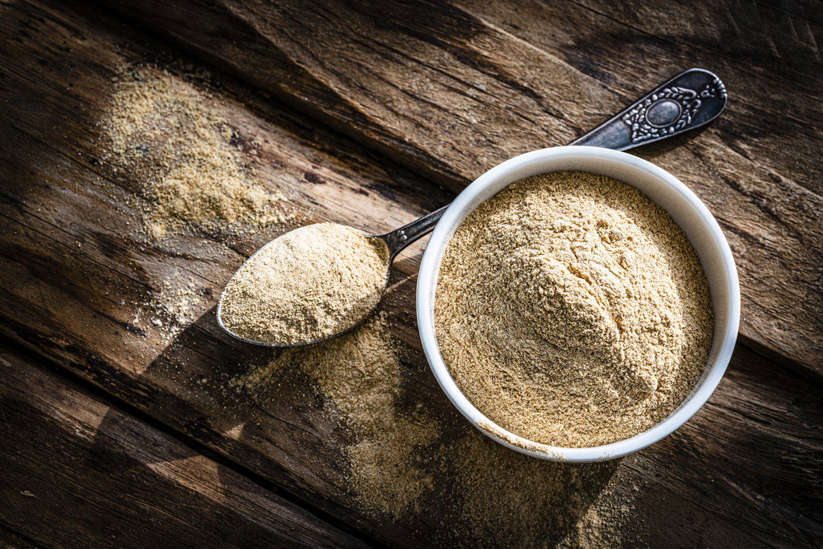 Maca-Pulver in Schüssel auf Holzbrett