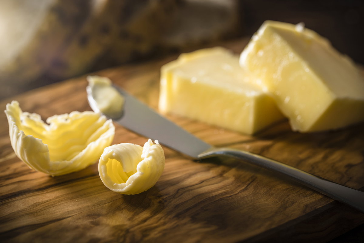 Nahaufnahme von Margarine und Buttermesser auf Holzbrett