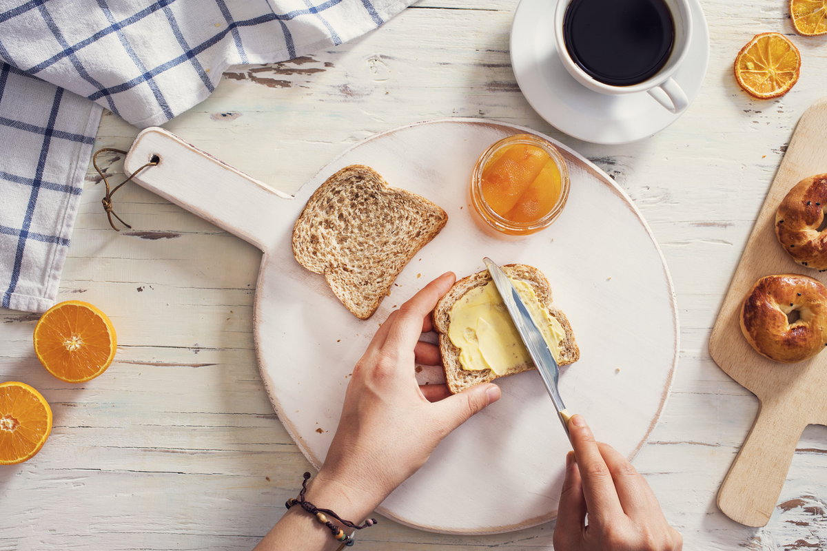 Mann schmiert Margarine auf Toast