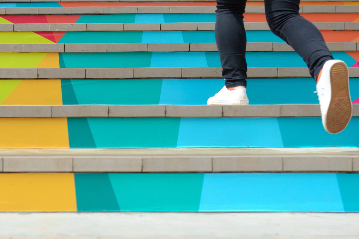 Mann geht bunte Treppen hoch
