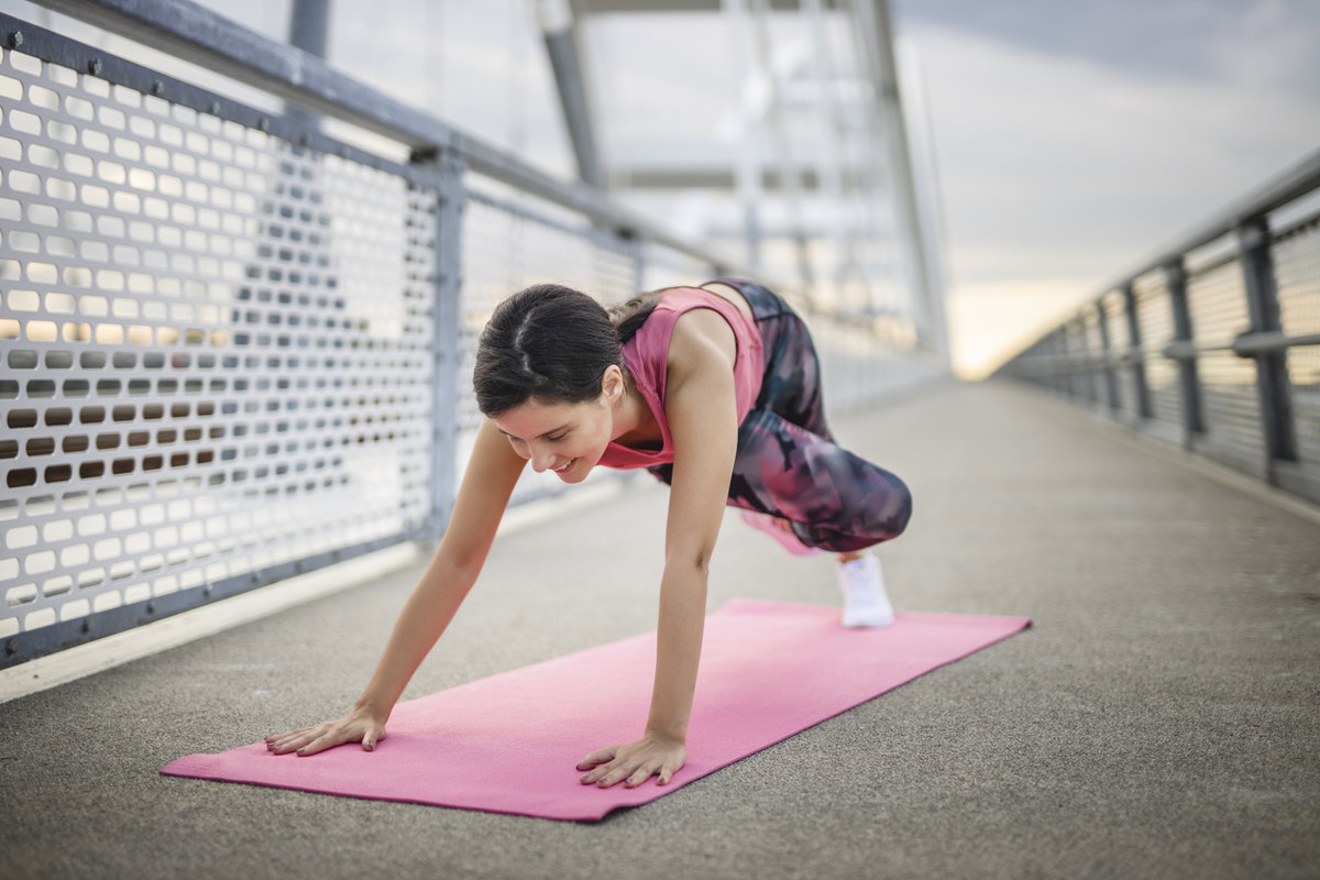 Frau macht Mountain Climbers mit Rumpfdrehung auf Brücke
