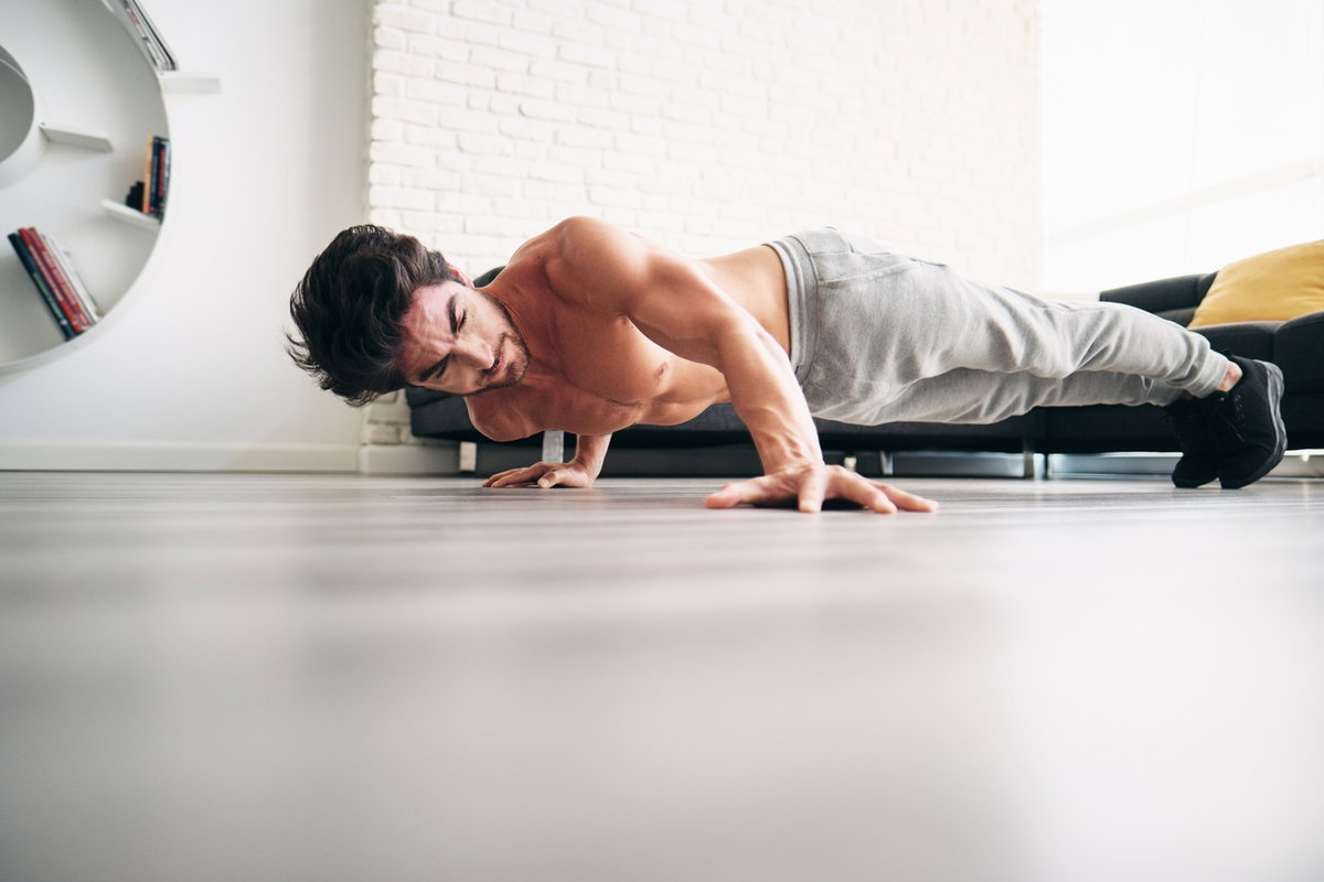 Mann macht Archer Push-ups in der Wohnung