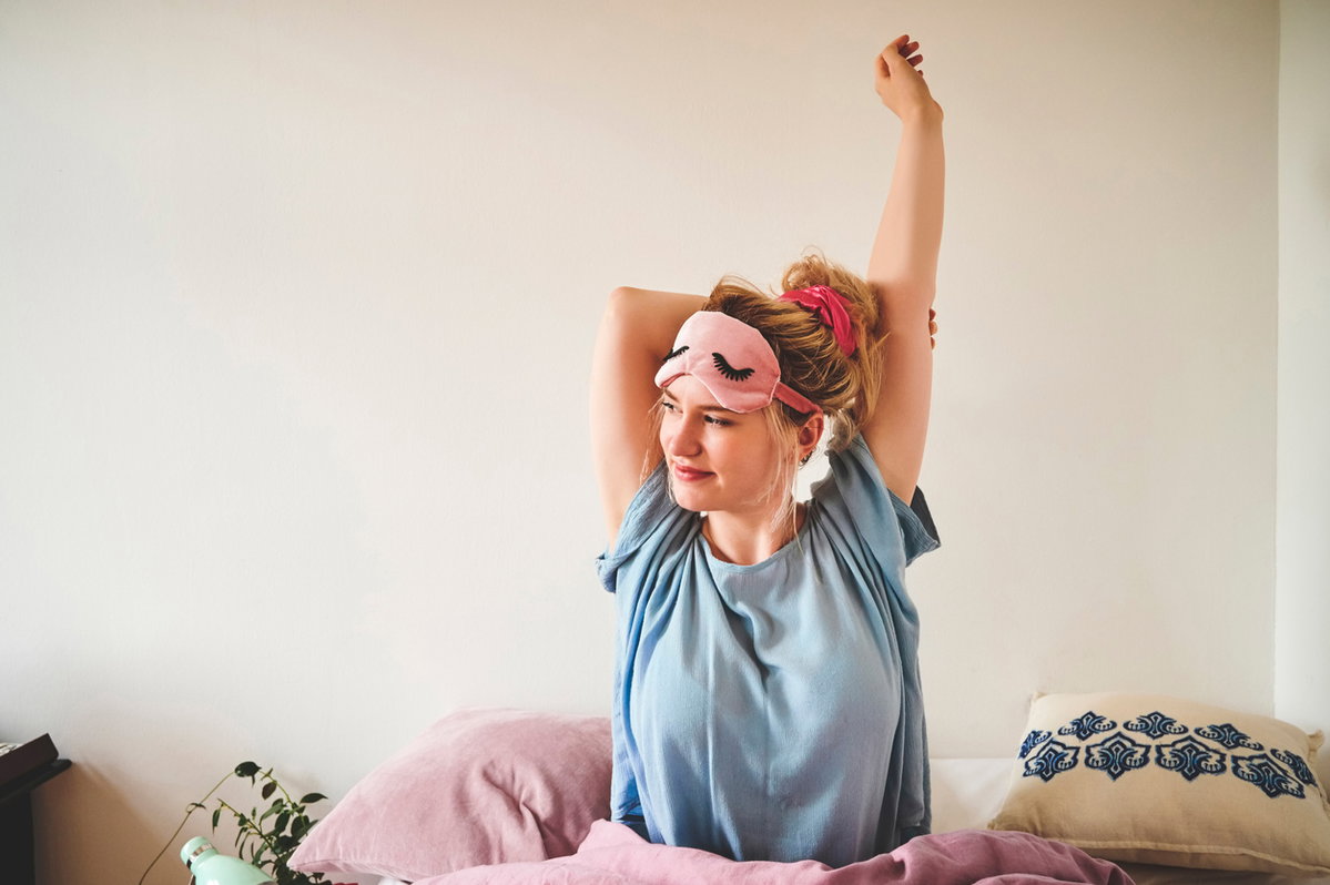 Frau streckt sich im Bett