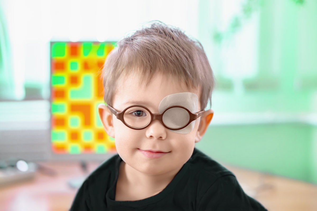 Ein kleiner Junge mit Brille und Augenklappe