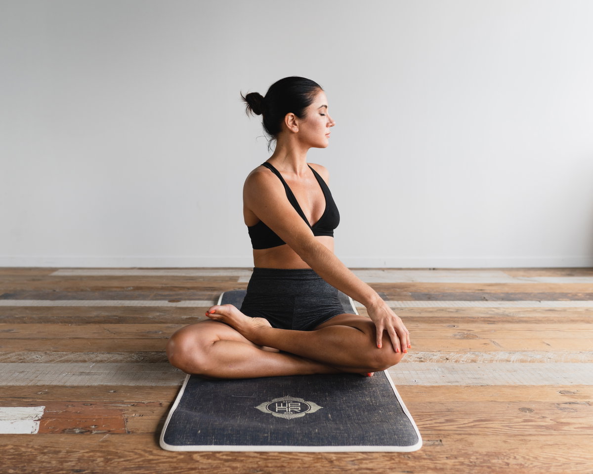 Frau auf Matte macht Yoga