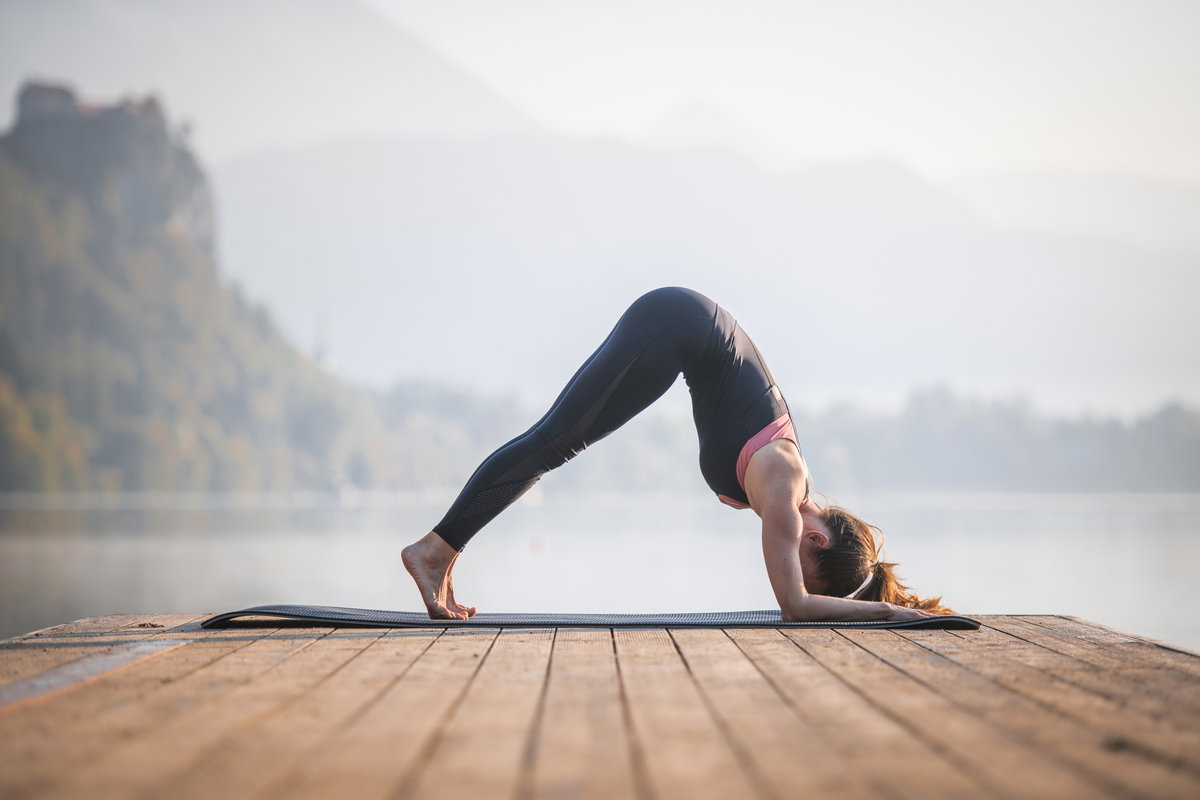 Junge Frau in Dolphin Pose auf Pier