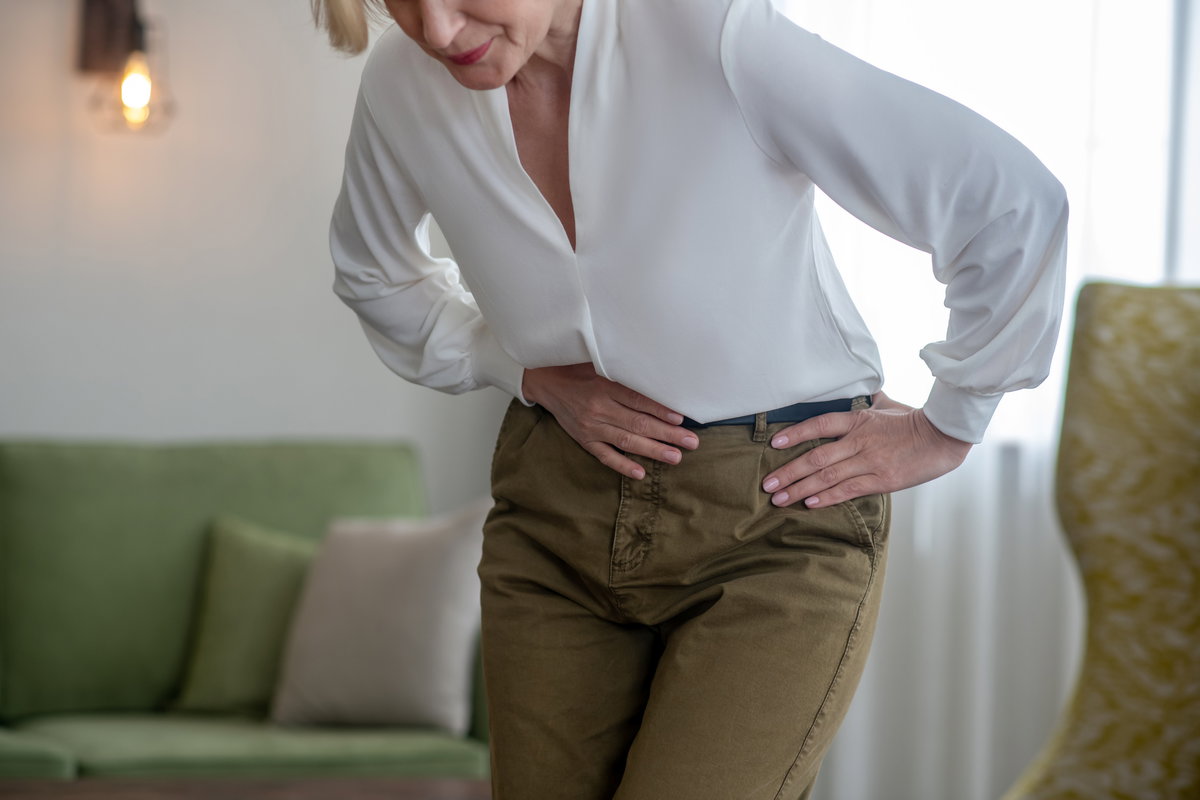 Ältere Frau hält sich den Bauch