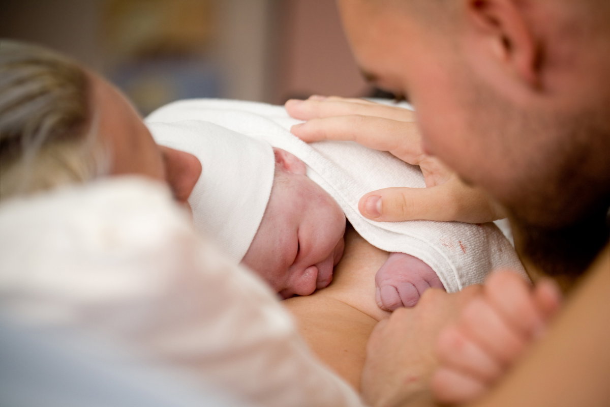 Neugeborenes schläft auf Brust von Mutter