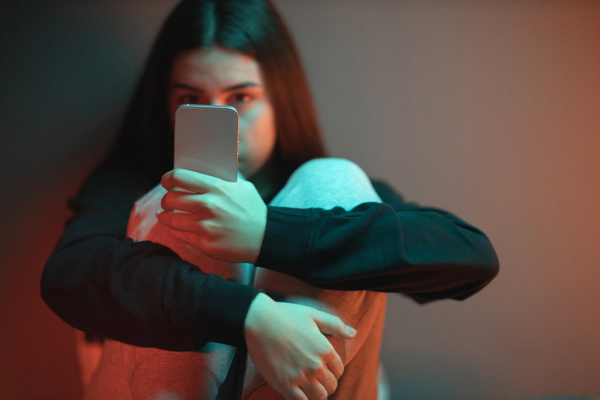 Junges Mädchen starrt süchtig auf Handy