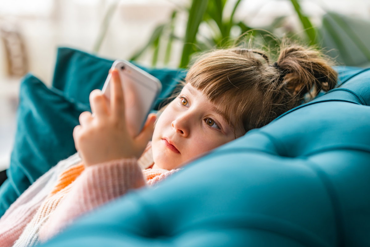 Kleines Mädchen starrt auf Handy