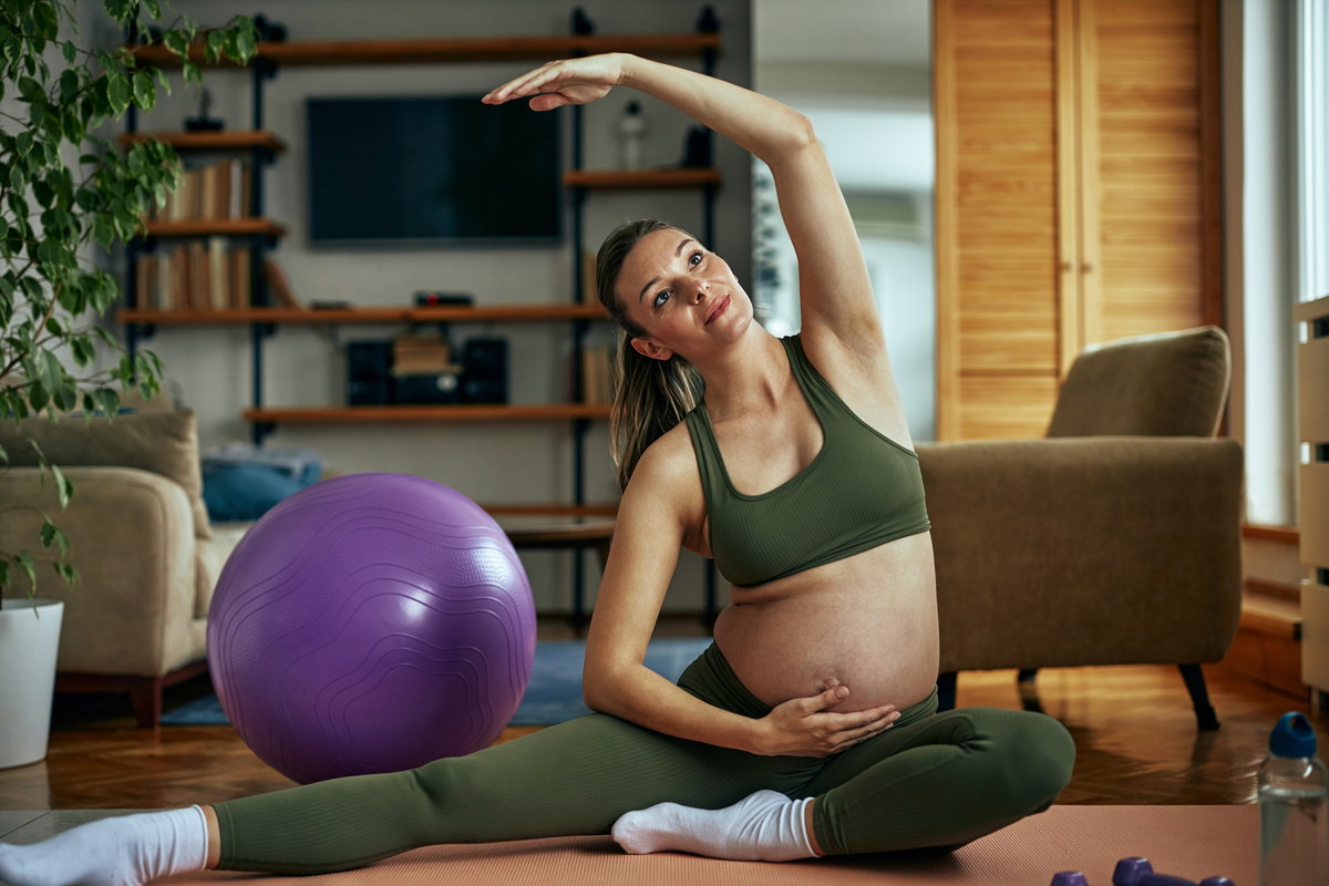 Schwangere Frau macht Sport-Übungen