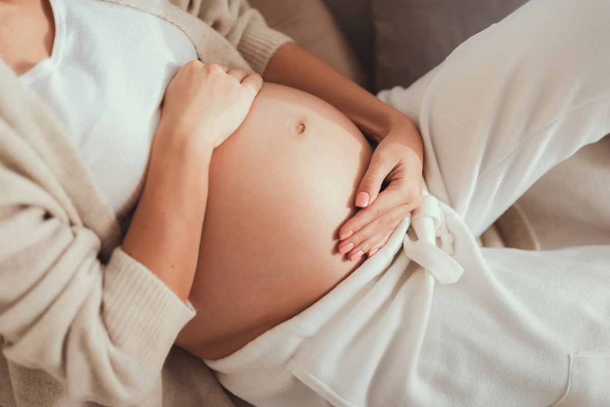Schwangere hält Hände auf dem Bauch