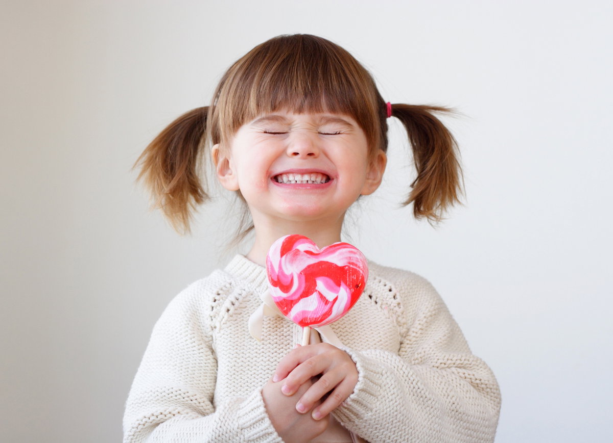 Kleines Mädchen lacht mit Riesenlolli