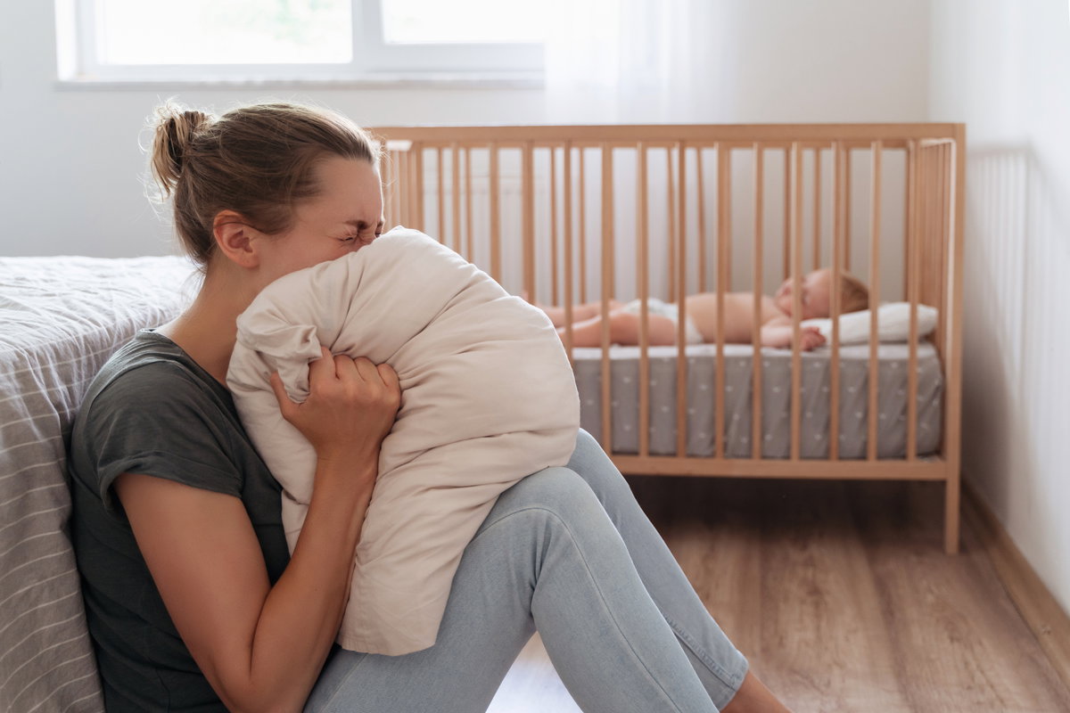 Depressive Mutter, die vor Verzweiflung im Kissen schreit