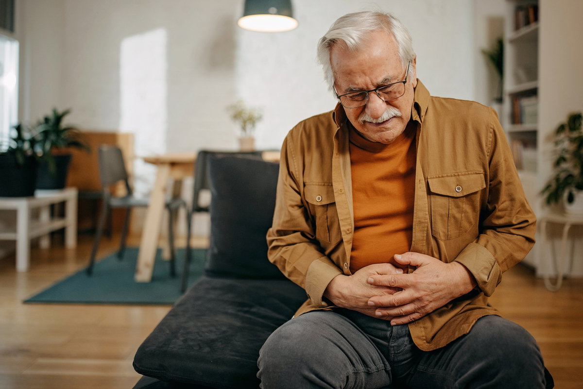 Älterer Mann hält sich schmerzenden Unterbauch