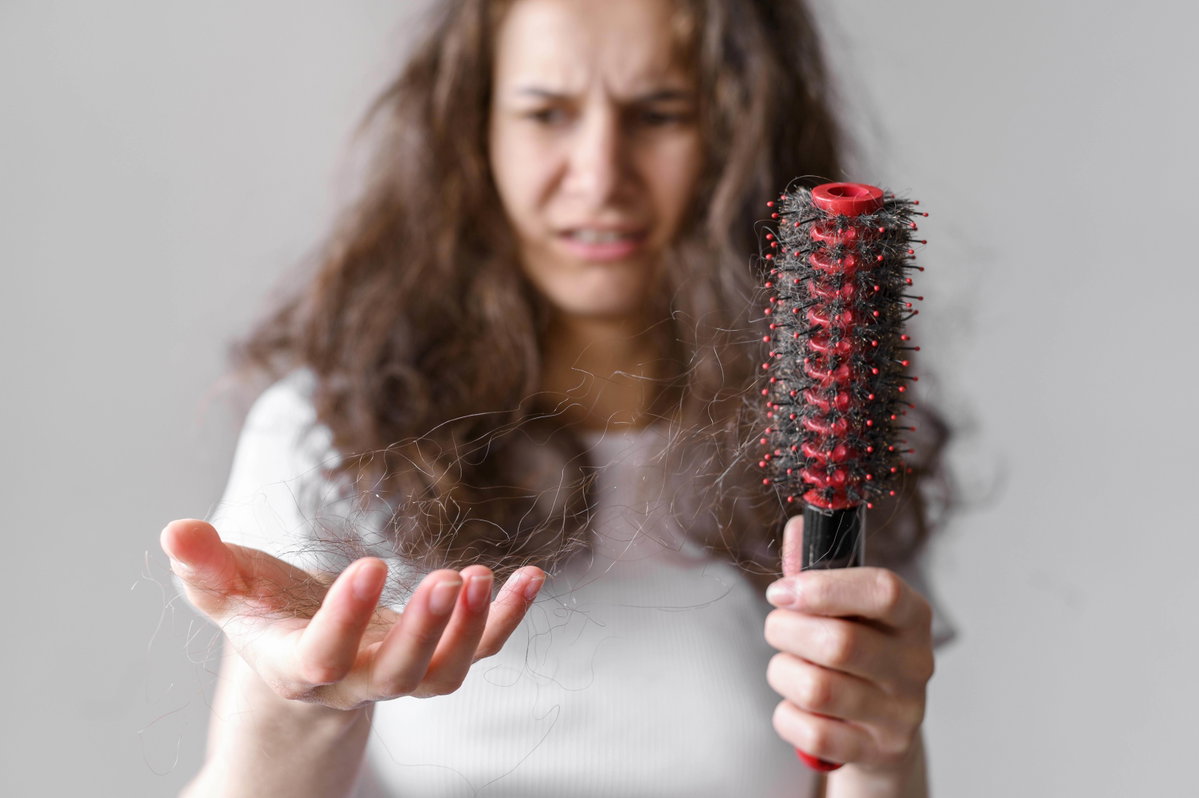 Frau hält ausfallende Haare in den Händen