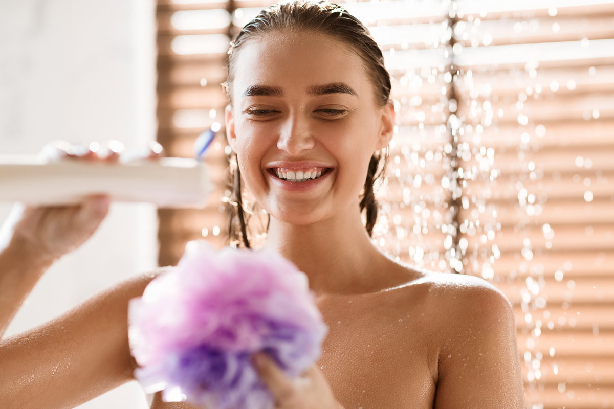 Frau mit Duschschwamm in Dusche