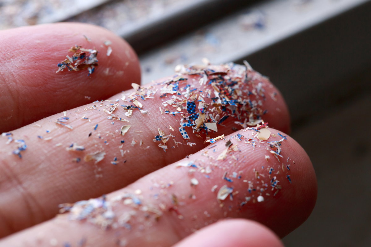 Kleine Plastikteilchen auf Fingerspitzen