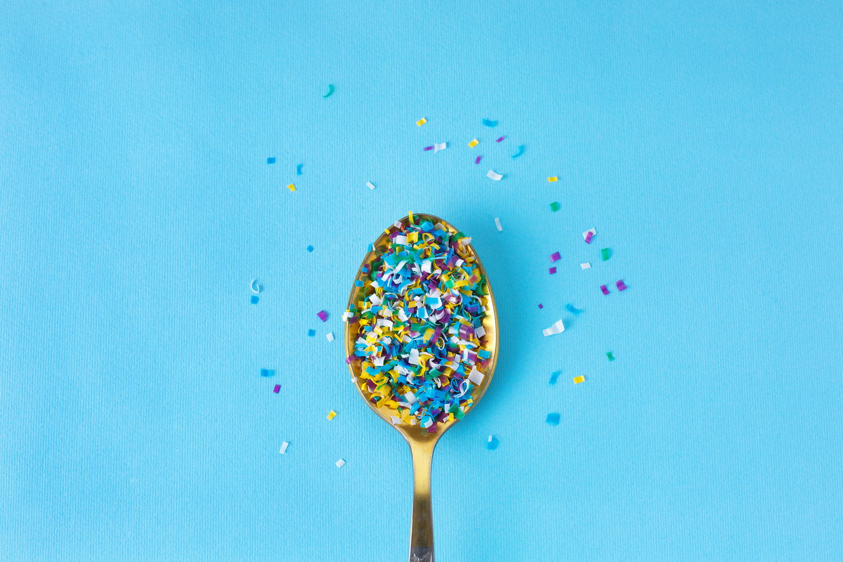 Mikroplastik auf Teelöffel vor blauem Hintergrund