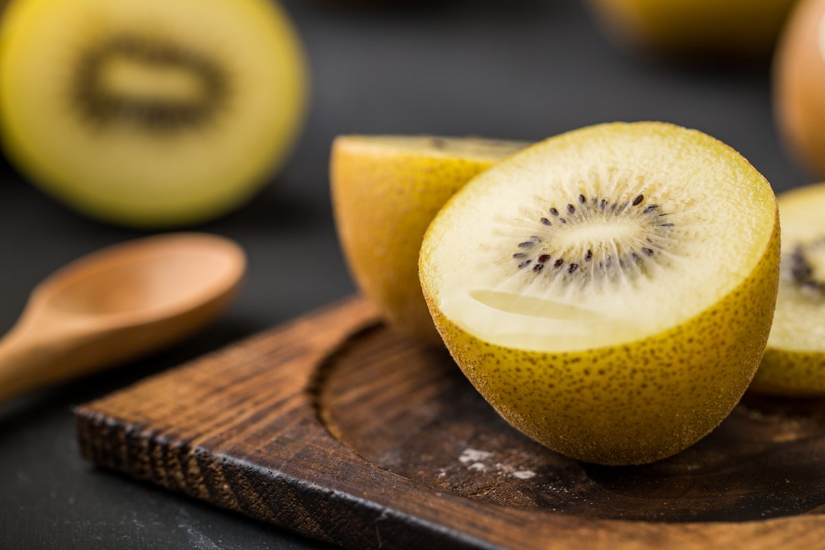 Gelbe Kiwi liegt auf einem Holzbrett