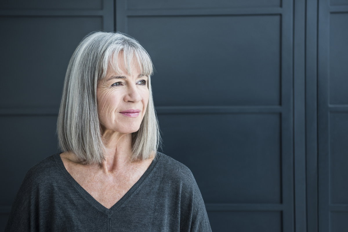 Frau mit grauen Haaren trägt einen Long Bob mit Pony