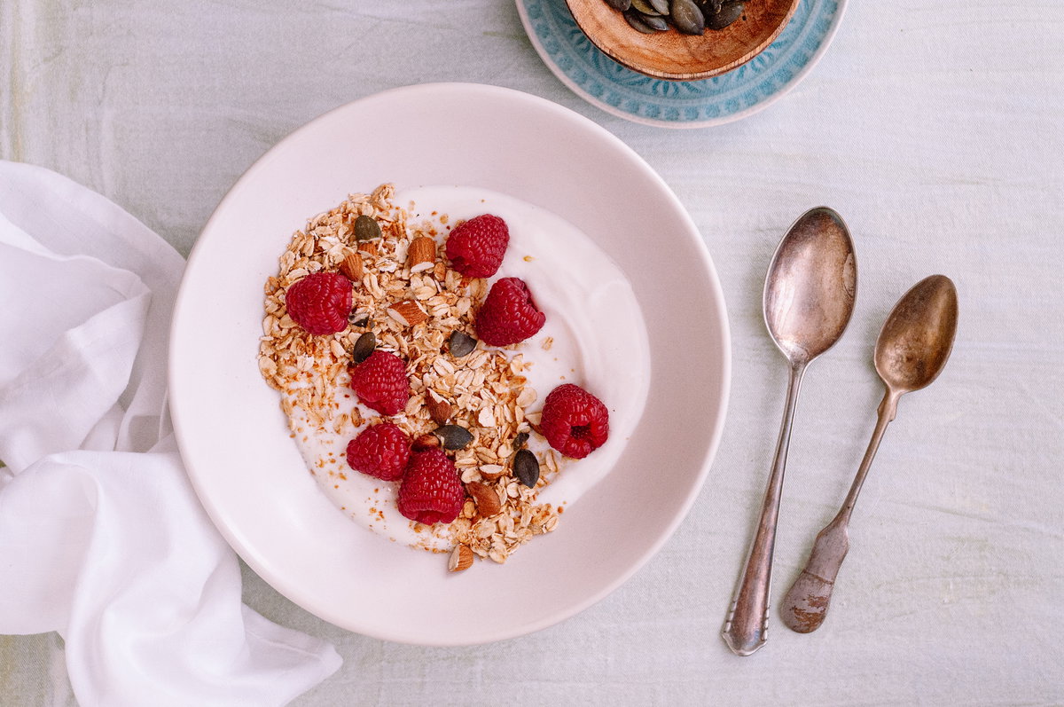 Quark oder Joghurt in einer Schüssel mit Himbeeren