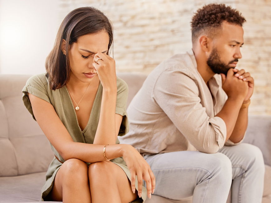 Paar sitzt nach Streit gemeinsam auf dem Sofa