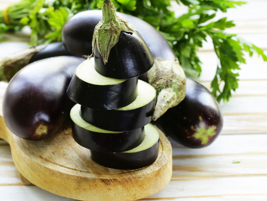 Aufgeschnittene Aubergine auf einem Brett