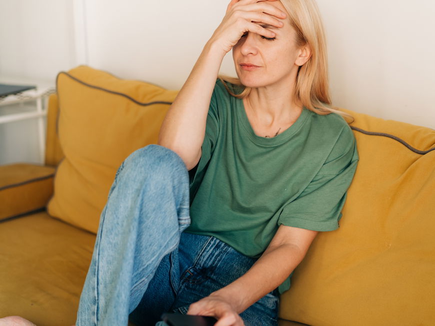 Unglückliche Frau sitzt auf Sofa