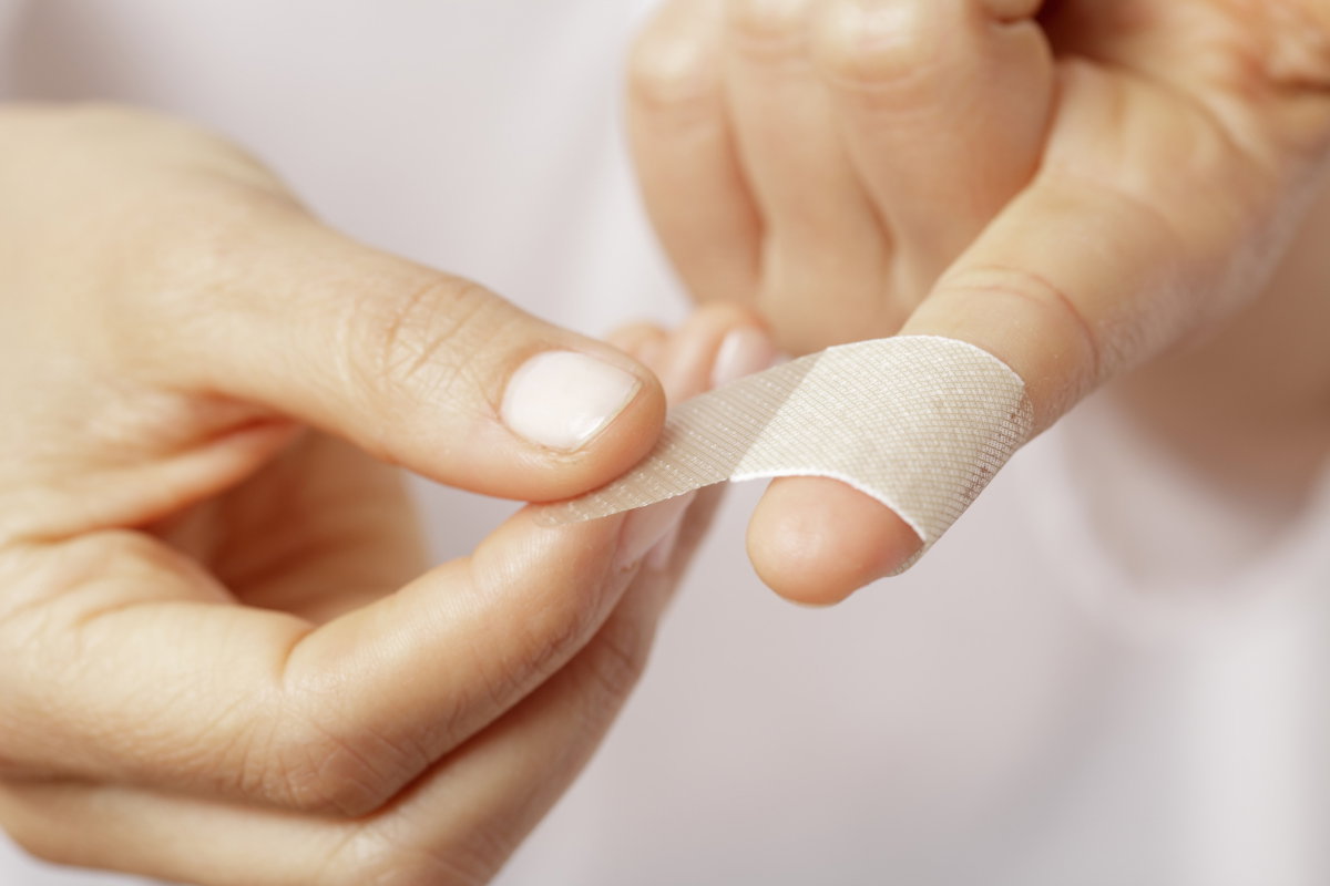 Pflaster wird auf Finger geklebt