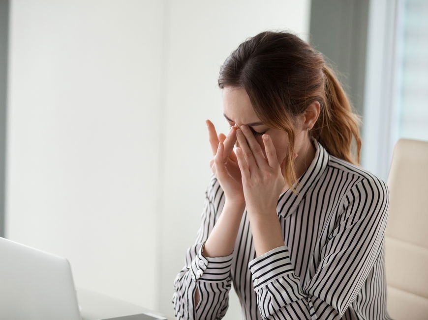 Frau vor Laptop reibt sich trockene Augen