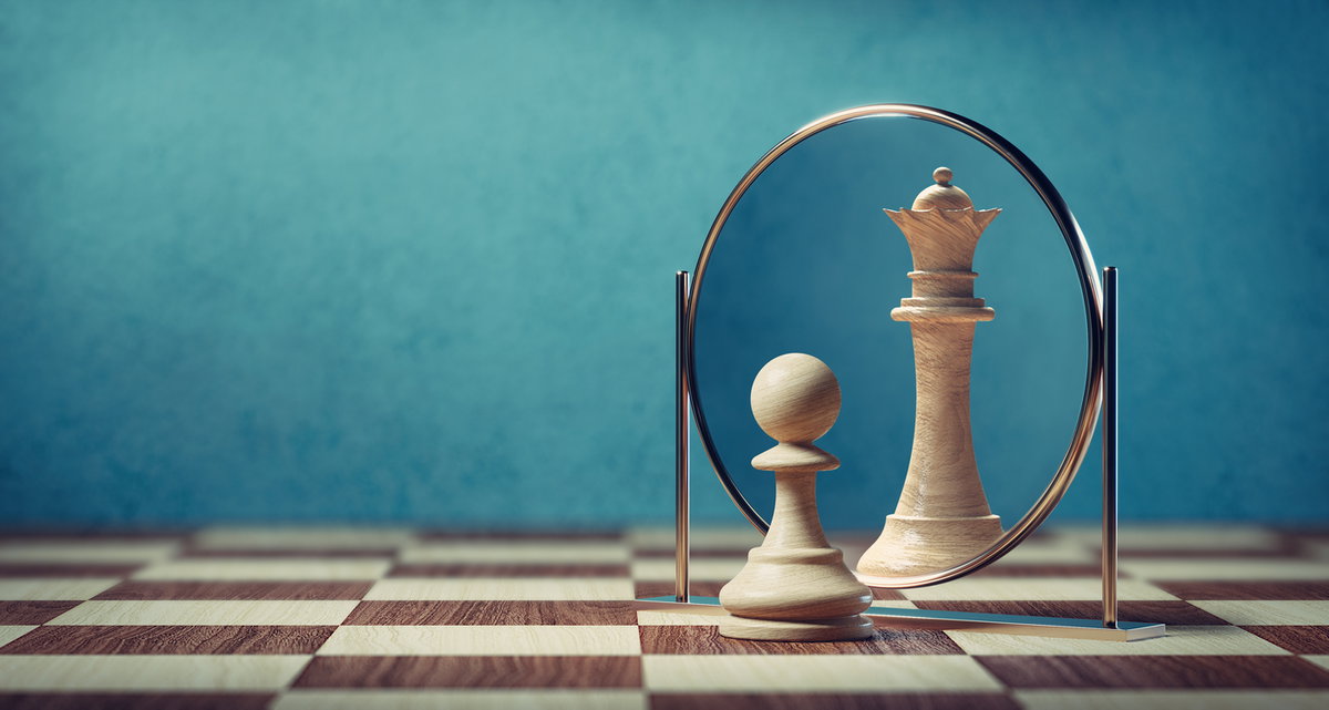 Darstellung einer Bauernfigur beim Schach, die im Spiegel eine Dame sieht