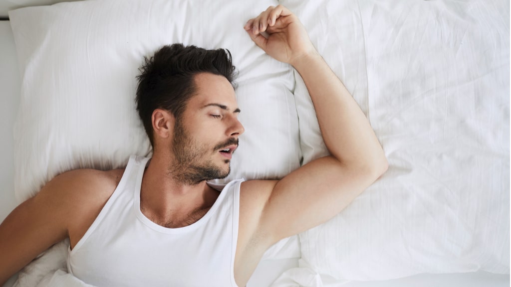 Mann schläft auf dem Bett