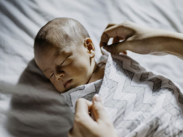 Baby wird in eine Decke eingewickelt