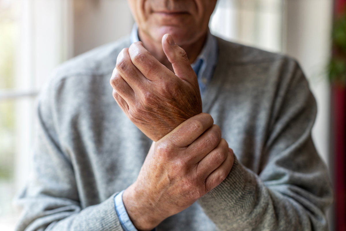 Mann hält sich die schmerzende Hand