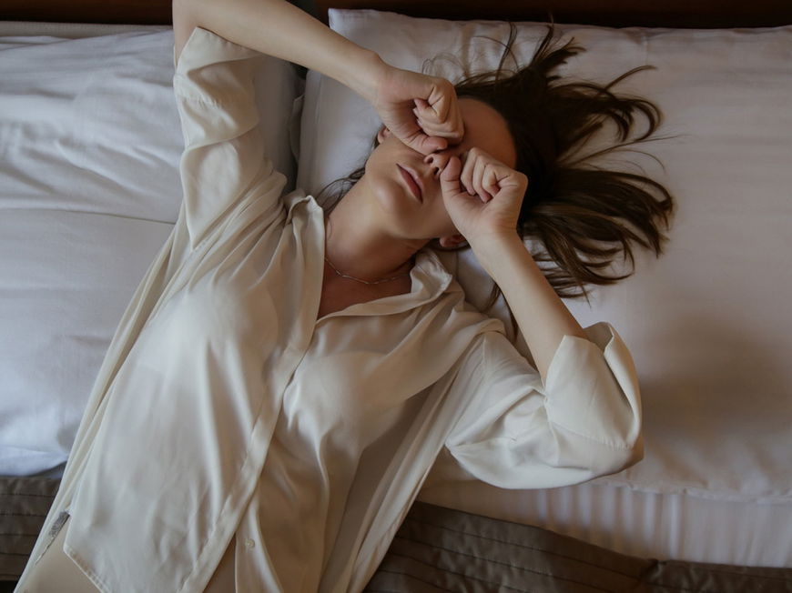 Frau liegt wach im Bett und kann nicht schlafen