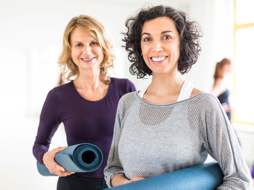 Zwei ältere Frauen mit Sportmatten
