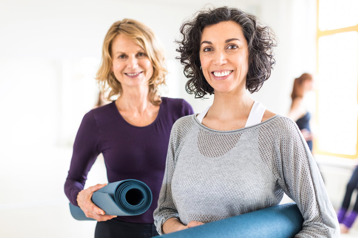 Zwei ältere Frauen mit Sportmatten