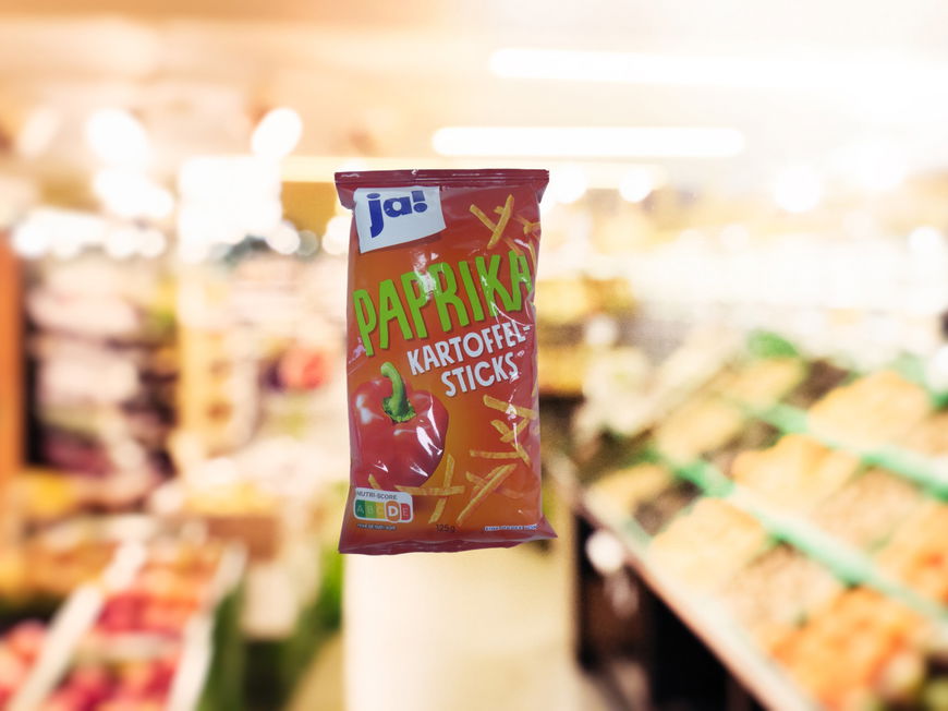 Kartoffelsticks vor Supermarkthintergrund