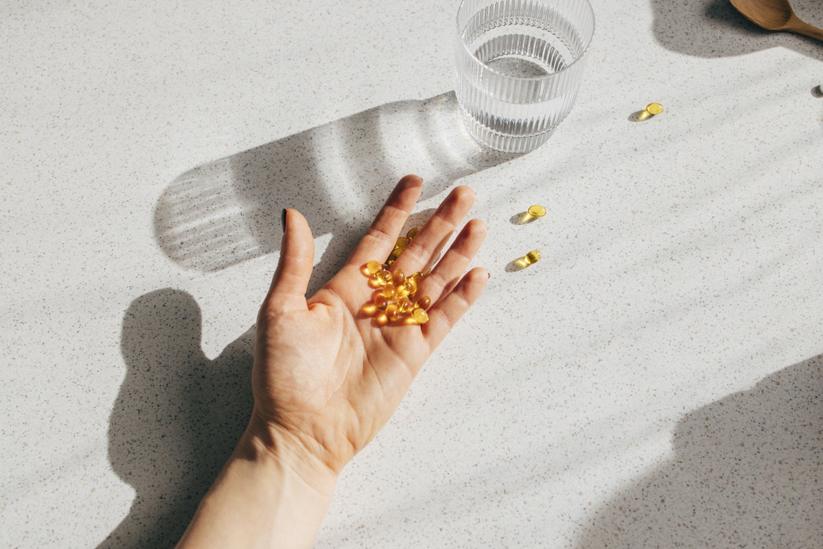 Hand mit Vitamin-D-Tabletten darin