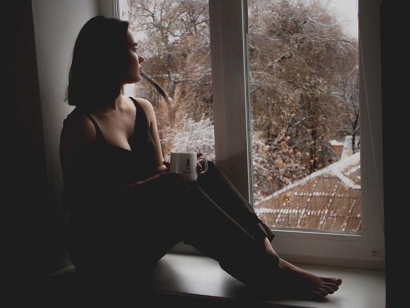 Junge Frau sitzt am Fenster