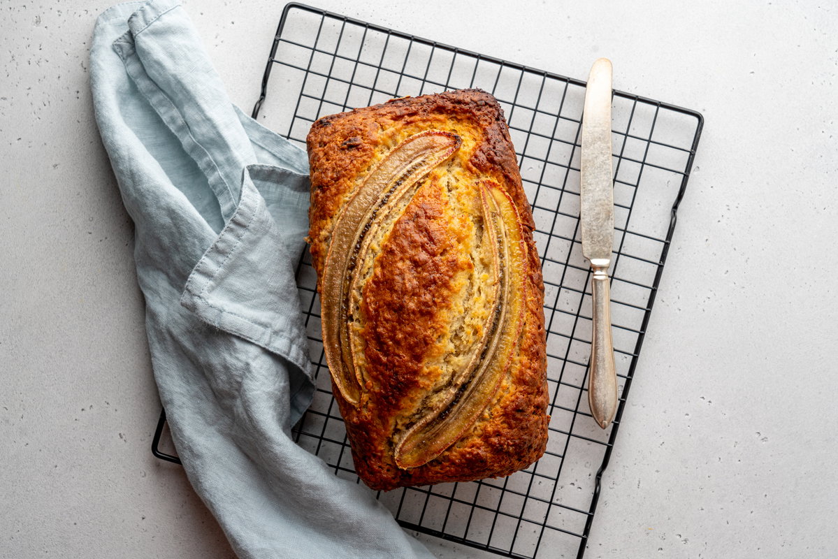 Bananenbrot angerichtet mit einem Messer auf einem Rost