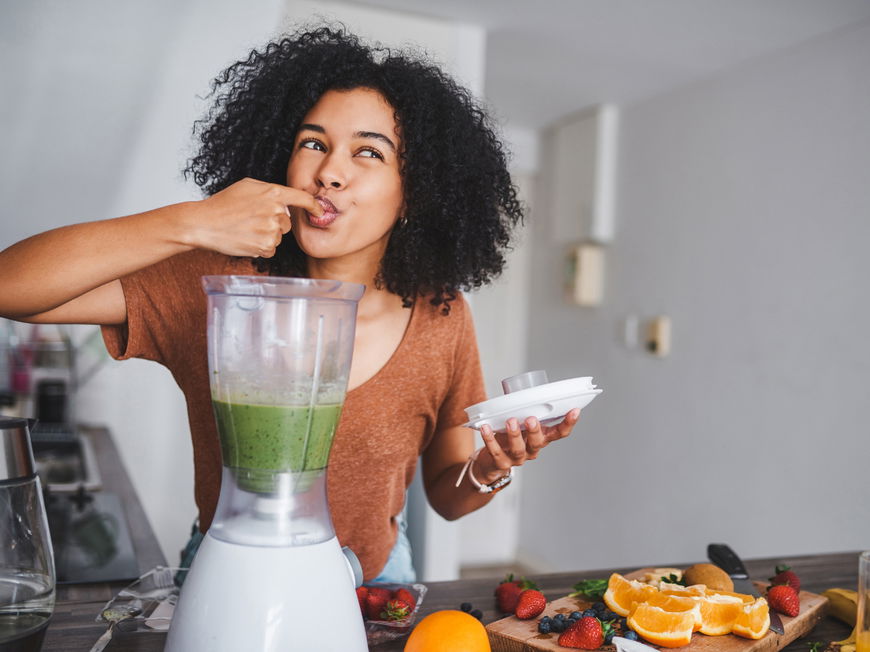 Junge Frau mixt einen Shake