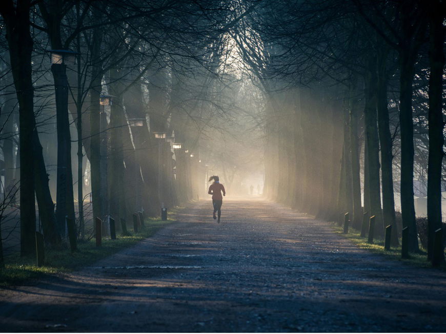 Eine Frau joggt im Herbst durch den Wald