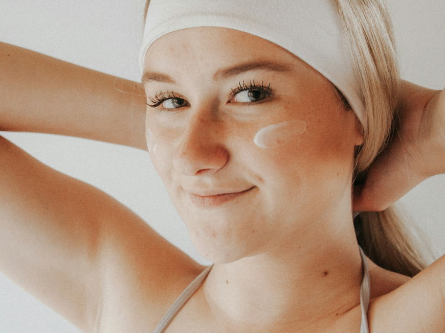 Frau mit Creme im Gesicht