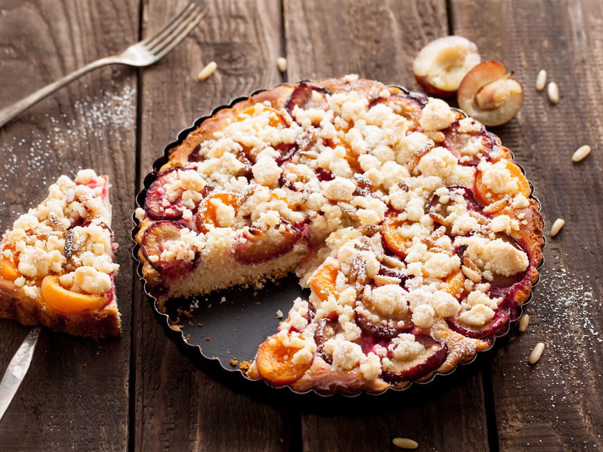 Angeschnittener Pflaumenkuchen auf einem Blech