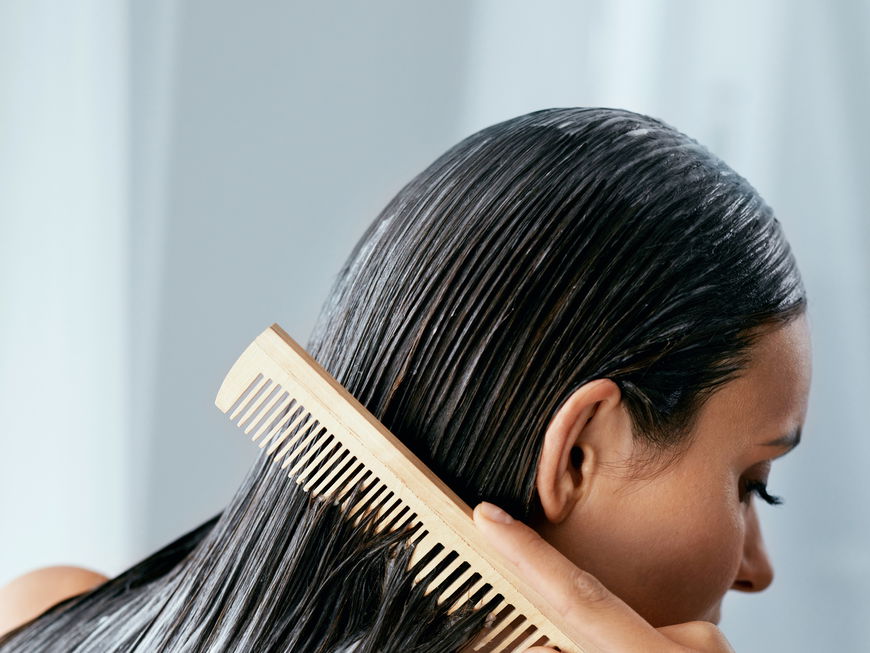 Eine Frau kämmt eine Haarpflege ein