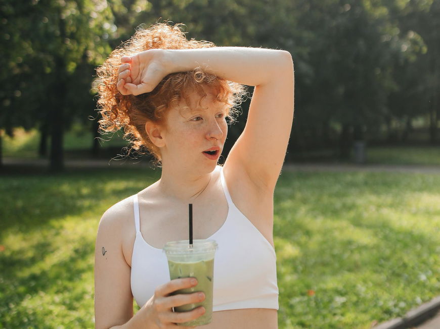 Frau schwitzt im Park