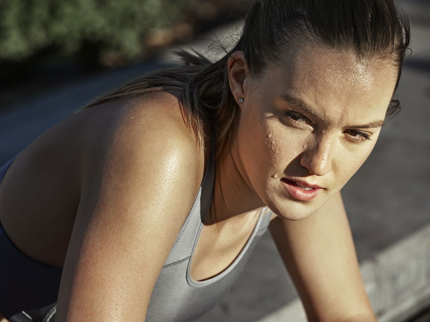 Junge Frau schwitzt beim Sport im Freien