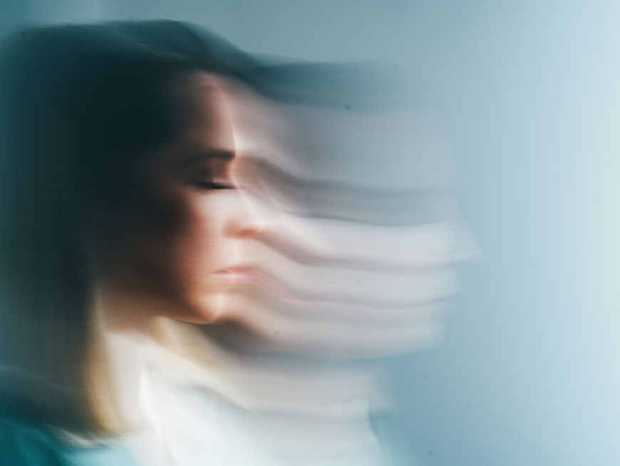 Eine Frau wirkt verzerrt vor blauem Hintergrund